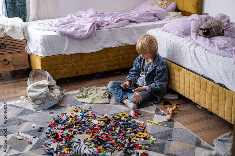 Fotografia do Stock: boy using phone, playing phone games in messy ...