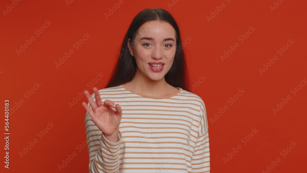 Ok. Joyful happy pretty woman in pullover looking approvingly at camera showing approve feedback gesture like sign positive something good. Young girl on red studio background. People sincere emotion Ok. Joyful happy pretty woman in pullover looking approvingly at camera showing approve feedback gesture like sign positive something good. Young girl on red studio background. People sincere emotion