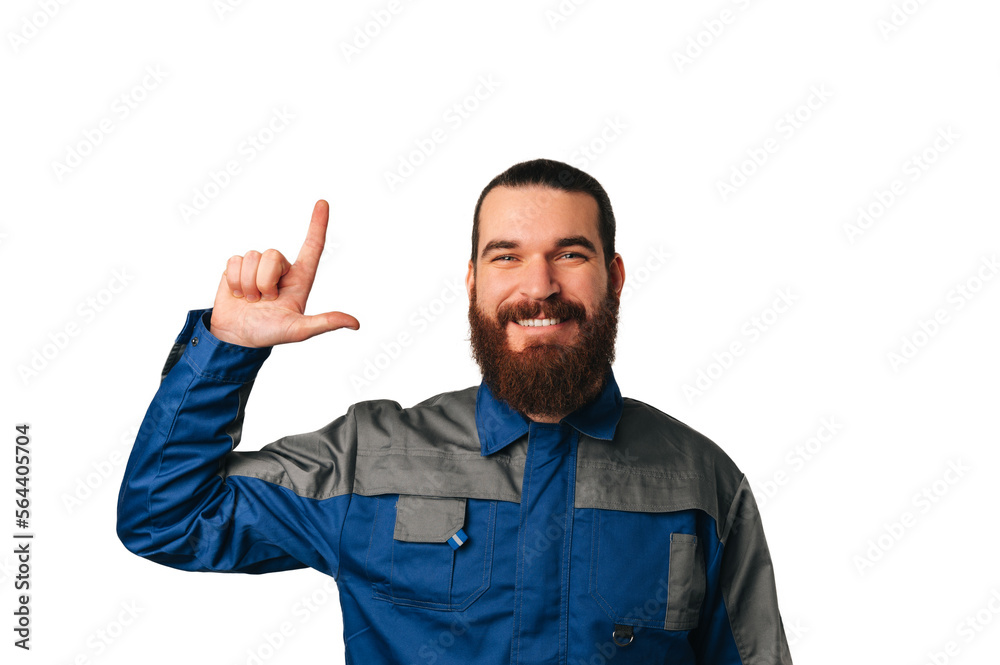 Smiling bearded male engineer wearing blue uniform points up to copy space. Smiling bearded male engineer wearing blue uniform points up to copy space.