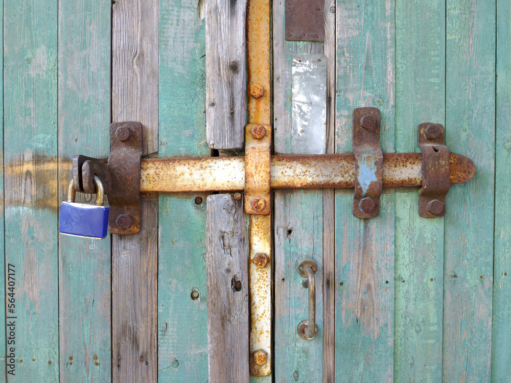 old door with iron bolt and padlock. protection from strangers and theft. attachments for protecting property and premises from unauthorized access old door with iron bolt and padlock. protection from strangers and theft. attachments for protecting property and premises from unauthorized access