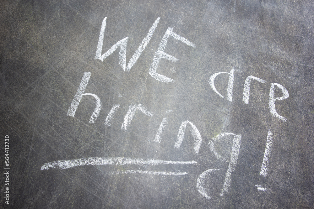Fototapeta premium Text We are hiring handwritten with white chalk on a blackboard