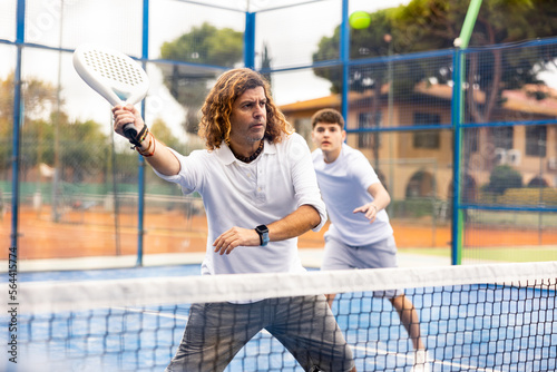 Caucasian man playing paddle tennis on the padel court