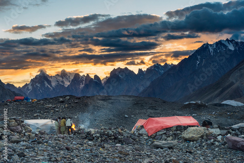Pakistani porters around campfire at Concordia during sunset, K2 base camp trek, Karakoram, Pakistan