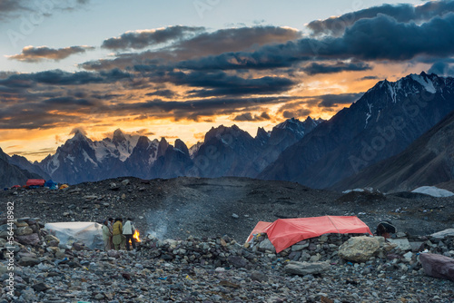 Pakistani porters around campfire at Concordia during sunset, K2 base camp trek, Karakoram, Pakistan photo