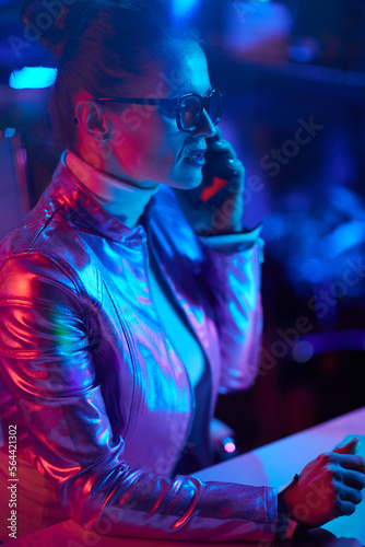 stylish woman in glasses speaking on smartphone