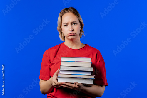 Lazy schoolgirl or student is dissatisfied with amount of books homework on blue