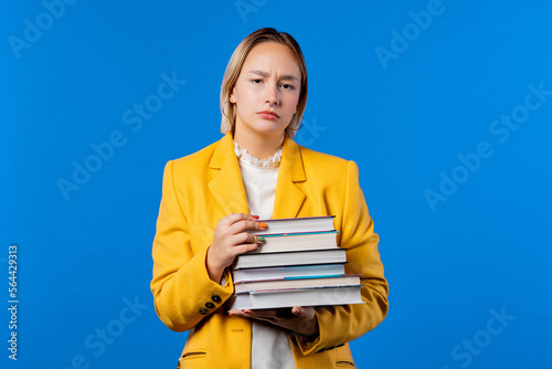 Lazy student woman is dissatisfied with amount of books homework on blue