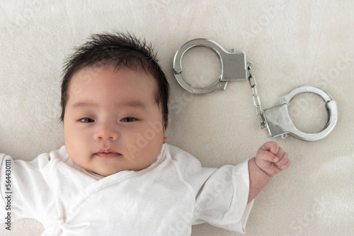 起きている赤ちゃんと玩具の手錠（0歳1か月、日本人、男の子） photo