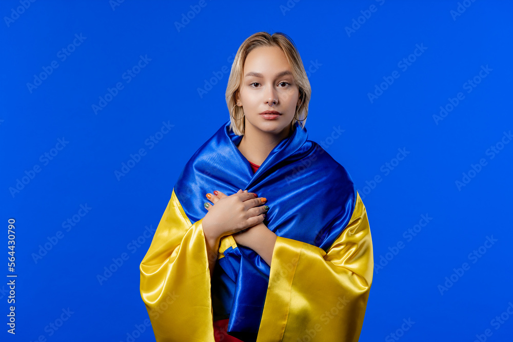 Blonde woman with national Ukrainian flag on blue. Ukraine, patriot, victory Blonde woman with national Ukrainian flag on blue. Ukraine, patriot, victory