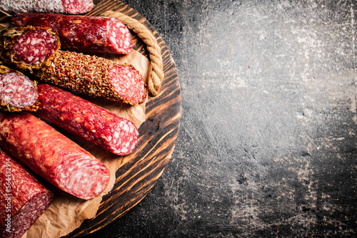 Various salami sausage on a wooden tray. 