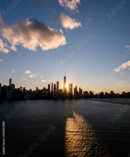 Beautiful downtown Chicago skyline aerial over Lake Michigan during the Chicago henge or autumn equinox as the golden colored sun aligns with the streets between high-rise buildings.