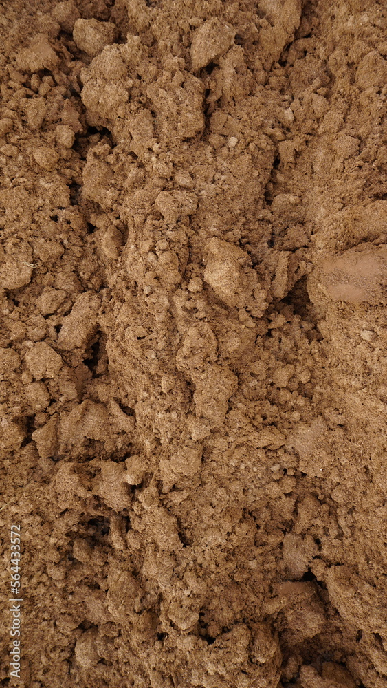 Closeup of macro view of red dirt or mud of pile soil from agriculture land. Soil Background.