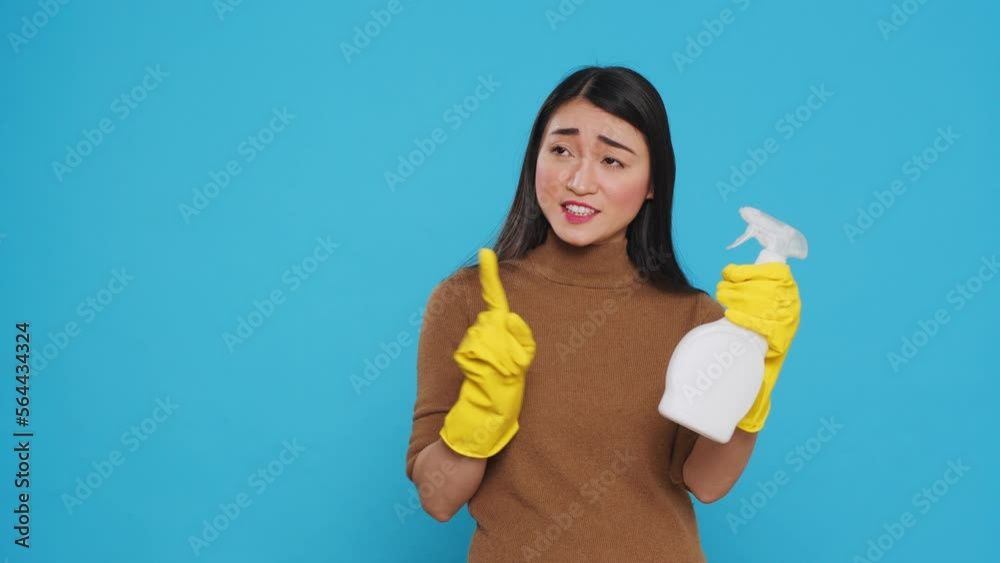 Professional maid pointing and showing cleaning product or isolated text, using chemical spray bottle filled to disinfect surfaces and prevent the spread of germs. Housecleaning concept Professional maid pointing and showing cleaning product or isolated text, using chemical spray bottle filled to disinfect surfaces and prevent the spread of germs. Housecleaning concept