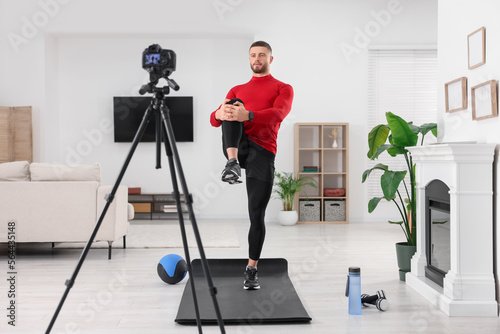 Trainer recording workout on camera at home