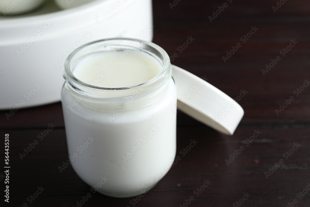 Glass jar with tasty yogurt on wooden table, closeup Glass jar with tasty yogurt on wooden table, closeup
