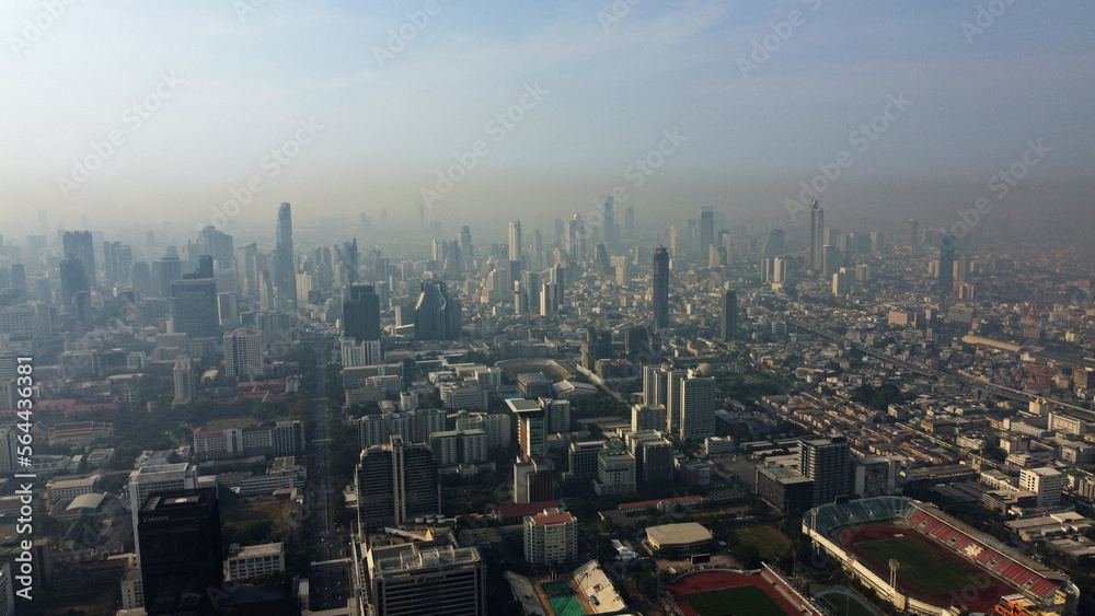 Aerial drone view of a thick layer of air pollution and dust covering the city during morning time in Bangkok, Thailand.