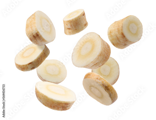 Pieces of parsnip root falling on white background