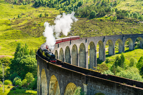 Glenfinnan Railway Viaduct in Scotland with the steam train passing over photo