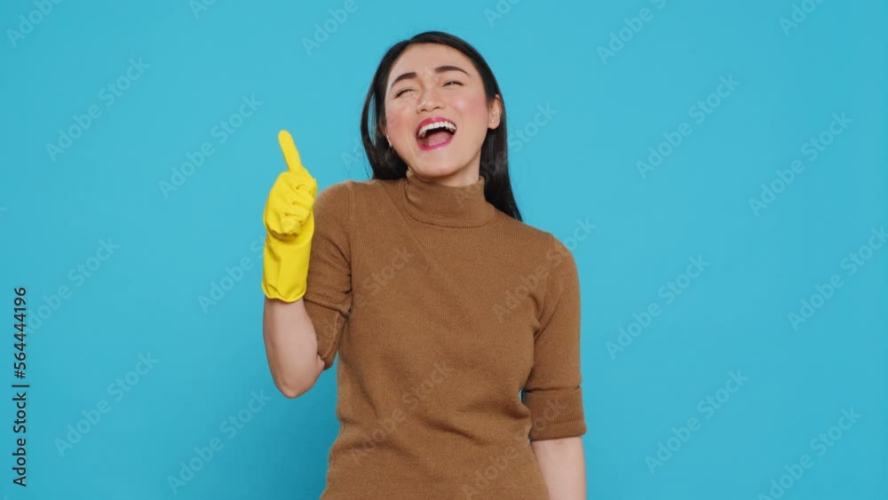 Smiling maid wearing yellow rubber gloves while doing ok gesture after finishing to clean client house, posing in studio. Cheerful housekeeper is responsible for providing cleaning services Smiling maid wearing yellow rubber gloves while doing ok gesture after finishing to clean client house, posing in studio. Cheerful housekeeper is responsible for providing cleaning services
