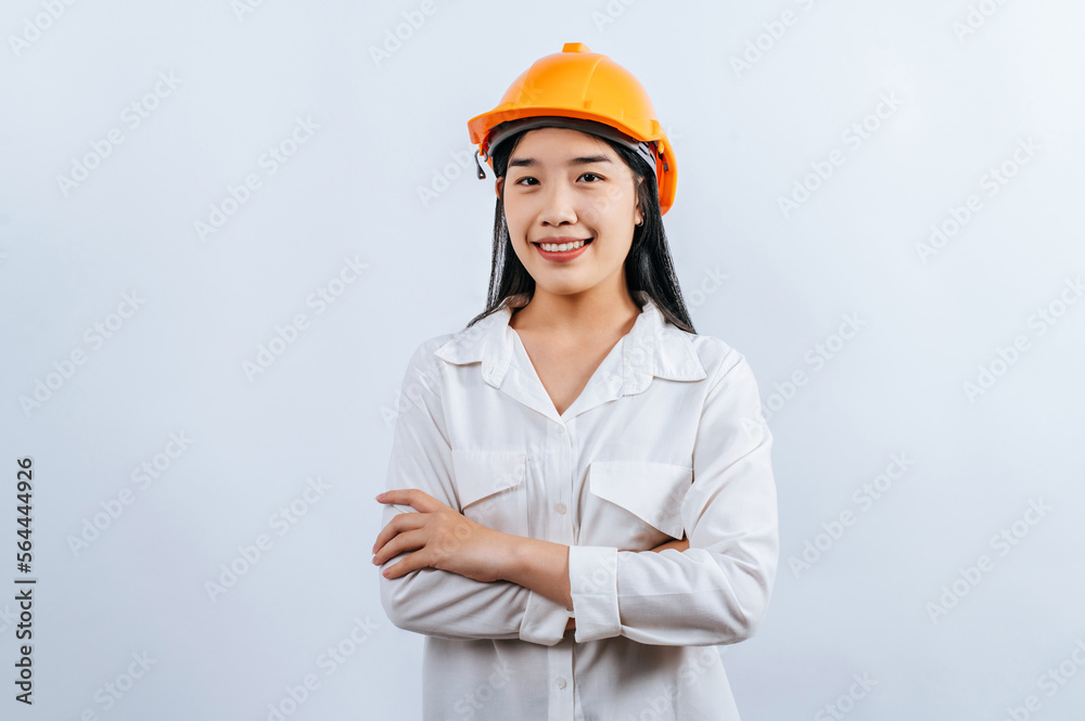Young female engineer wearing yellow helmet stand with charming smile posture Young female engineer wearing yellow helmet stand with charming smile posture