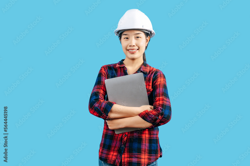 Young female engineer wearing helmet and use laptop computer Young female engineer wearing helmet and use laptop computer