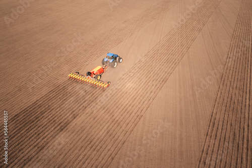 Tractor with seeder on field drone view photo
