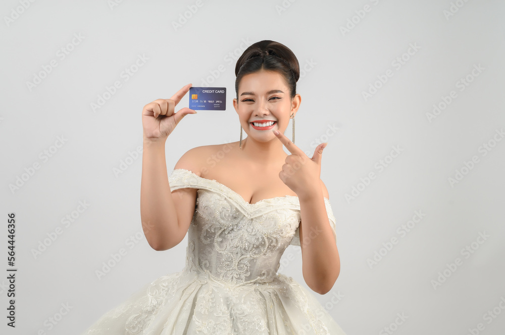 Young asian beautiful bride posting with credit card in hand Young asian beautiful bride posting with credit card in hand