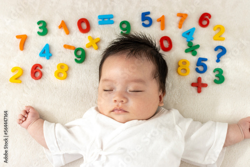 寝ている赤ちゃんと玩具の数字（0歳1か月、日本人、男の子） photo
