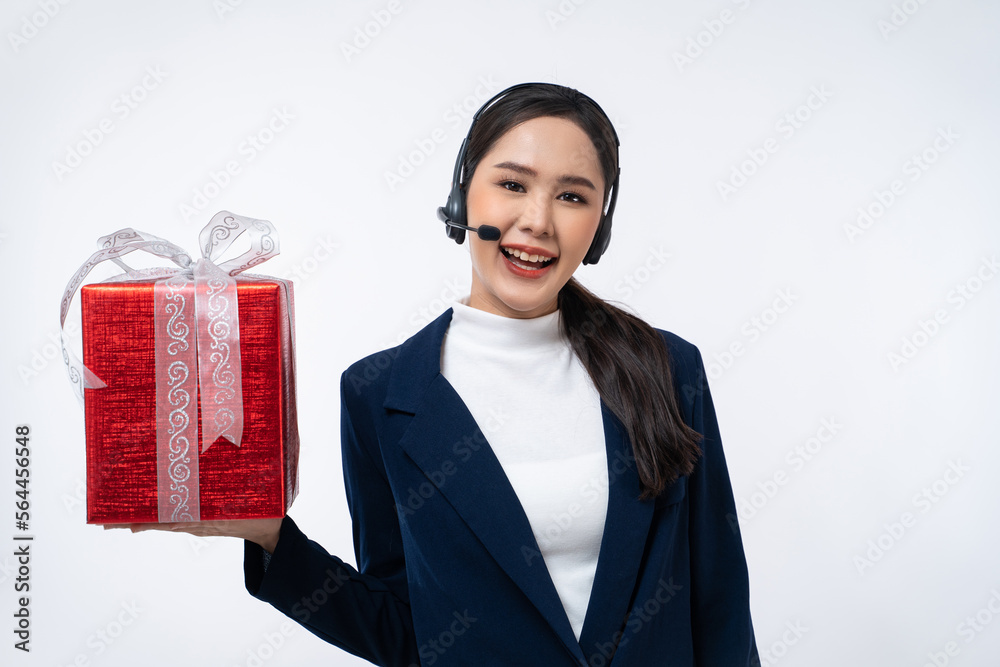 Happy young Asian operator woman agent with headsets working in a call center holding gift box isolated on white background. Happy young Asian operator woman agent with headsets working in a call center holding gift box isolated on white background.