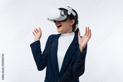Happy young Asian businesswoman working in virtual reality environment in VR glasses touching virtual interface isolated on white background. © Jirus
