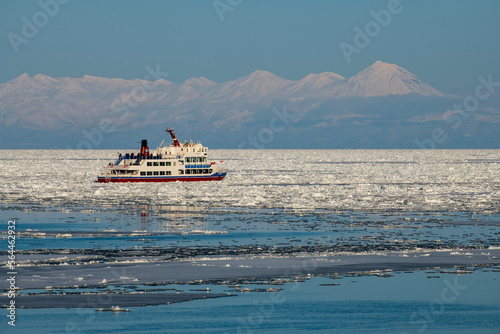 知床連山と流氷を割り進砕氷観光船