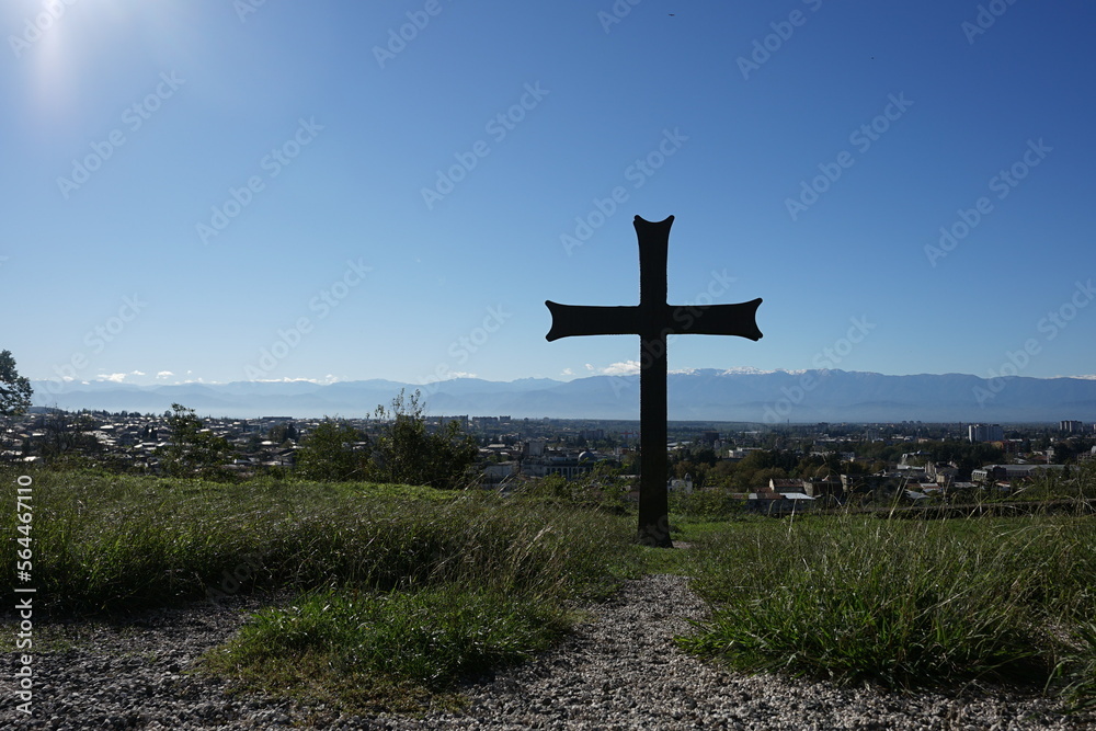 Christian cross on the ground with beautiful town background