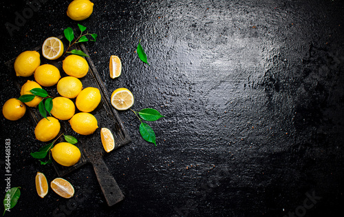 Pieces and whole lemons on a cutting board. 