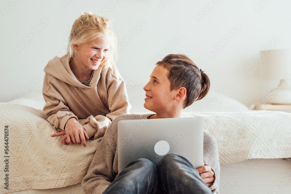 Boy and girl using laptop computer together. Teenagers spending time together.