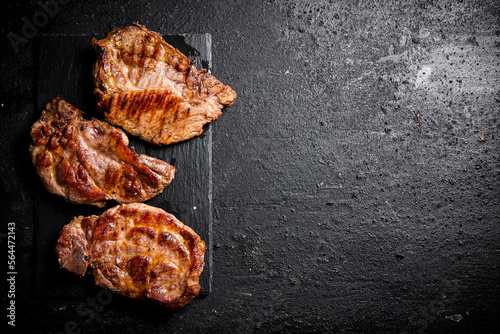 Delicious grilled pork steak on a stone board. 