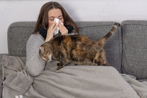 sick woman with tissue with her cat
