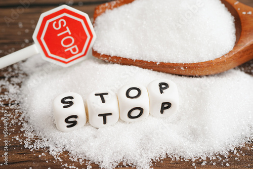 STOP, sweet granulated sugar with text, diabetes prevention, diet and weight loss for good health.