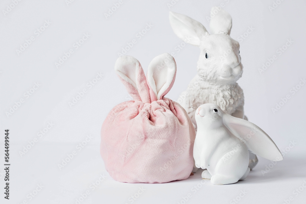 Obraz premium A beautiful postcard. Banner. The concept of a bright Easter holiday. White rabbits and Easter eggs on a white isolated background.