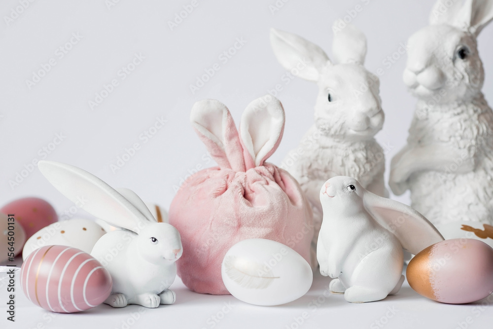 Obraz premium A beautiful postcard. Banner. The concept of a bright Easter holiday. White rabbits and Easter eggs on a white isolated background.
