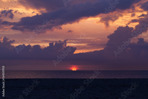 Coastal landscape with dramatic dark sky over ocean on a sunset