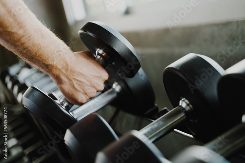 Smart sport man lifting dumbbell in fitness gym