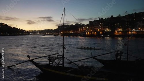 Rowing boat and Rabelo boats on Douro River at night photo