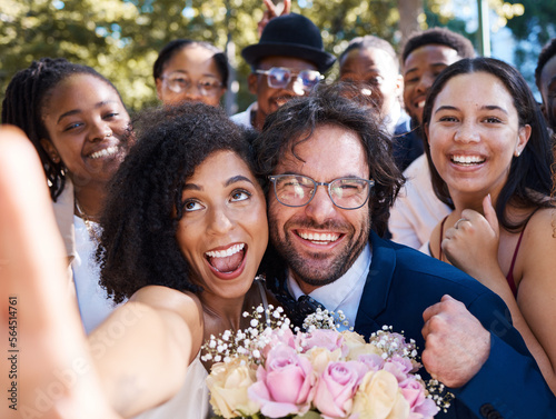 Friends, bride and groom with wedding selfie for outdoor ceremony celebration of happiness, love and joy. Marriage, happy and interracial relationship photograph of togetherness with excited guests