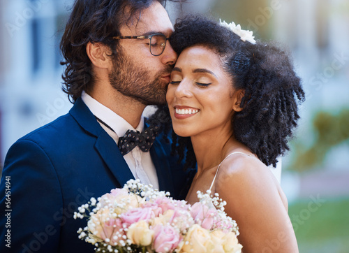Care, kiss and couple at wedding happy with romantic outdoor marriage event celebration with flowers. Partnership, commitment and trust embrace of interracial bride and groom with excited smile.