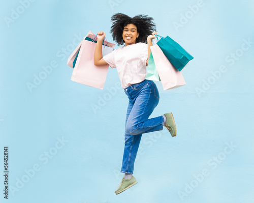 Happy, shopping and jump with portrait of black woman for spree, sale and summer discount. Retail therapy, spending and consumer deal with girl customer and bag for designer, products and purchase