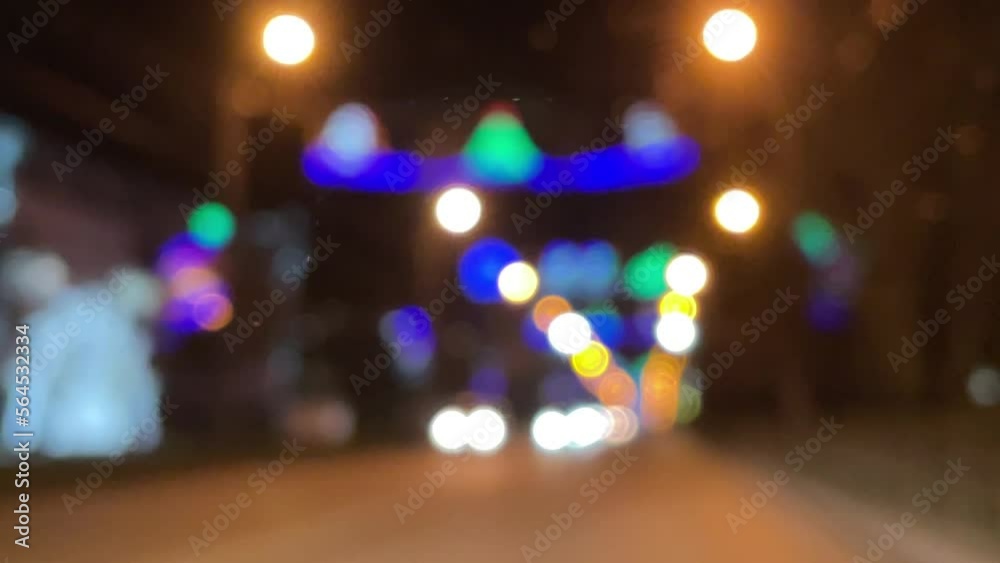 Blurred car lights bokeh in the evening city. Defocused headlights and street lighting at night. Moving bokeh circles of cars at night. Blurred city traffic background Blurred car lights bokeh in the evening city. Defocused headlights and street lighting at night. Moving bokeh circles of cars at night. Blurred city traffic background