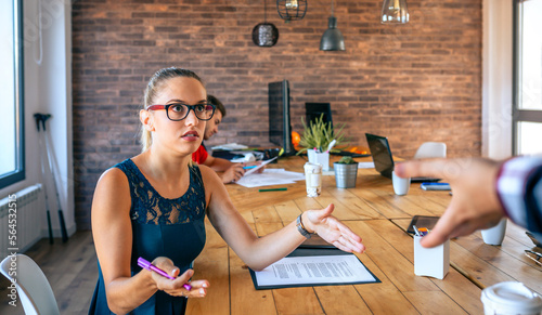 Close up of offended young woman arguing with her colleague for problems in coworking. Conflict at work concept.