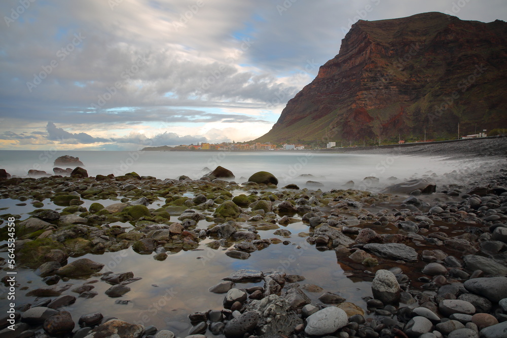 The rocky beach of La Playa in La Puntilla, Valle Gran Rey, Canary Islands, Spain, with plunging cliffs in the background
