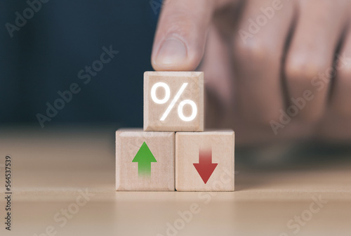 Wooden cube blocks with percentage icons and up or down arrows. Bank interest rates, stocks, dividends 