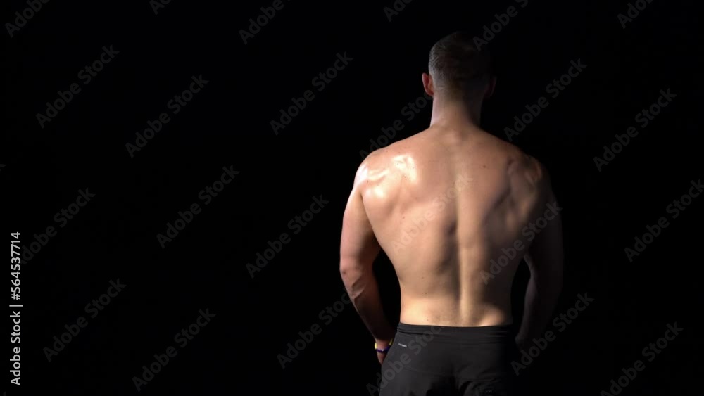 Back view of a muscular shirtless man playing with muscles Back view of a muscular shirtless man playing with muscles